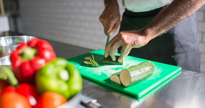 Hombre cortando un calabacín.